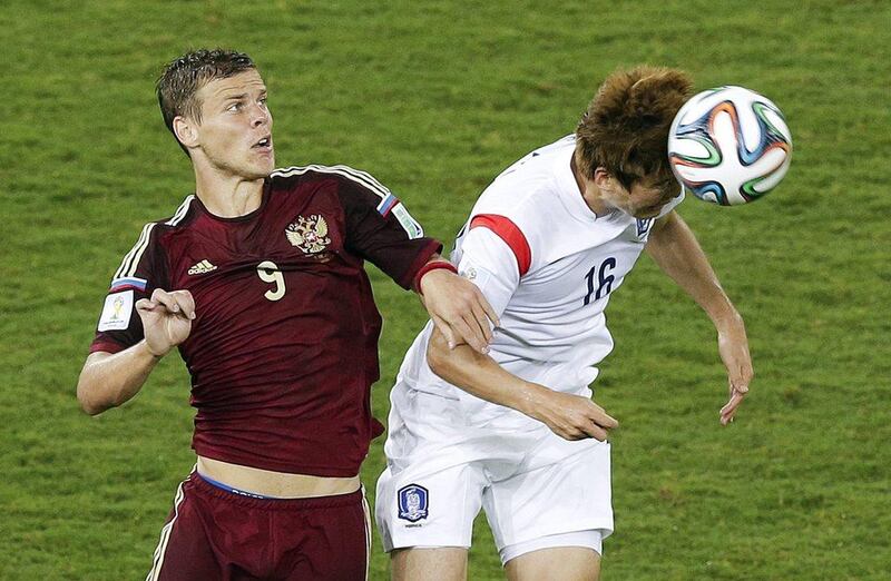 Russia's Alexander Kokorin, left, vies in the air for the ball with South Korea's Ki Sung-yueng, right, during their match on Tuesday at the 2014 World Cup in Cuiaba, Brazil. Thanassis Stavrakis / AP