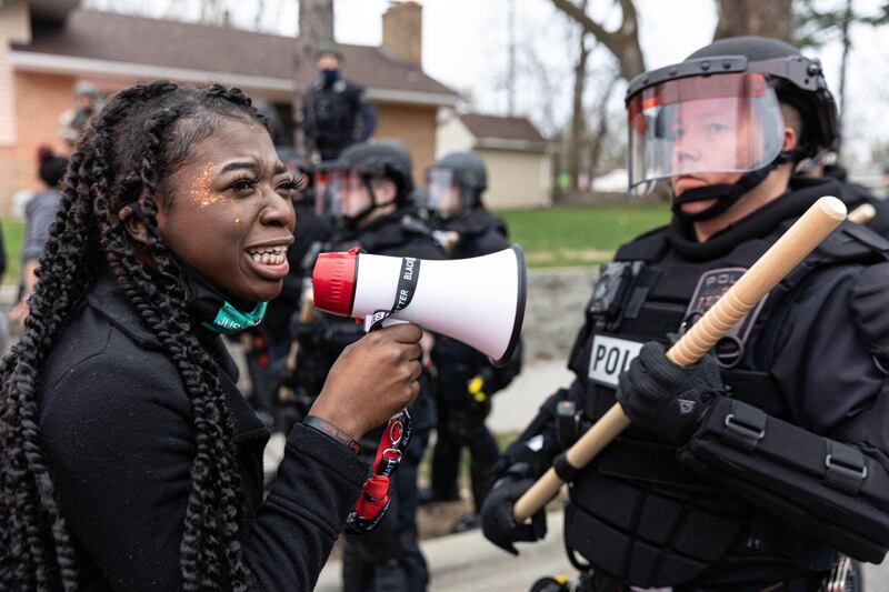 A woman confronts police officers standing in line as protesters gather after an officer reportedly shot and killed a black man in Brooklyn Centre, Minneapolis, Minnesota. AFP