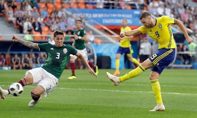 Mexico's Carlos Salcedo, left, and Sweden's Marcus Berg, right, challenge for the ball during the group F match between Mexico and Sweden, at the 2018 soccer World Cup in the Yekaterinburg Arena in Yekaterinburg , Russia, Wednesday, June 27, 2018. (AP Photo/Gregorio Borgia)