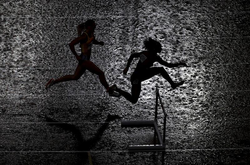 Athletes compete in the rain during a women's 400m hurdles semi-final race at Tokyo's Olympic Stadium at the Summer Games in Japan on August 2. Reuters