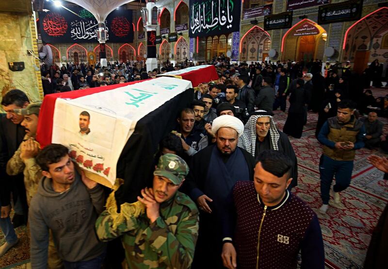 Mourners carry the flag-draped coffins of two fighters of the Popular Mobilization Forces, who were killed Sunday in an attack southwest of the northern city of Kirkuk, during their funeral in Najaf, Iraq, Monday, Feb. 19, 2018. Officials said Monday that Islamic State militants ambushed the group of Iraq's Shiite-led paramilitary fighters, killing at least 26 fighters. (AP Photo/Anmar Khalil)