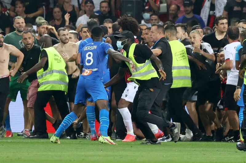 Security try to stop fans as they invade the pitch. AFP