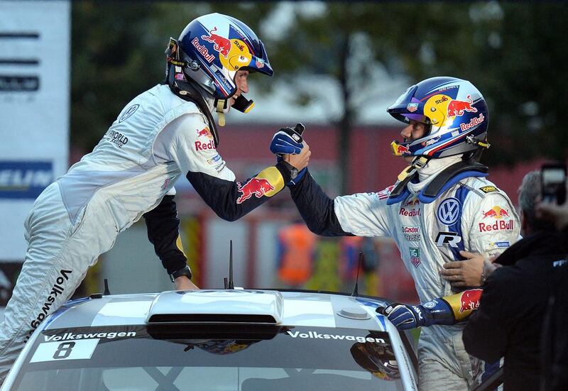 France's driver Sebastien Ogier, right, and his French co-driver, Julien Ingrassia, celebrate after winning their world champion title, shaking hands across the roof of their Volkswagen Polo R WRC at the Rally of France. Ogier, who clinched his first world rally title, succeeds compatriot Sebastien Loeb, who won the past nine WRC series titles.  Patrick Hertzog / AFP  