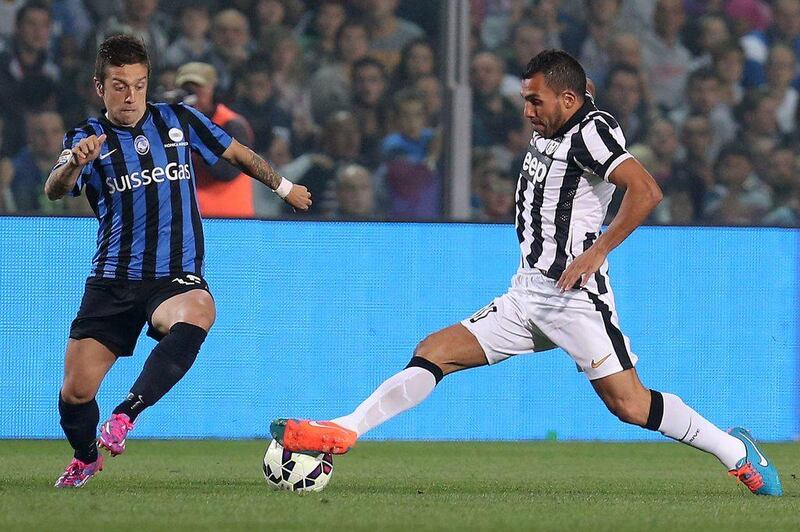 Juventus forward Carlos Tevez fights for the ball with Atalanta midfielder Maximiliano Moralez during Juventus' Serie A victory on Saturday. Marco Bertorello / AFP / September 27, 2014