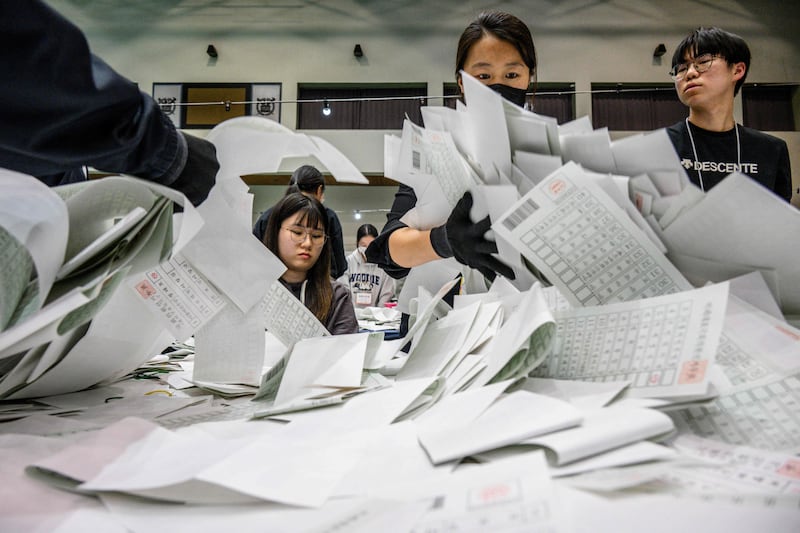 Election officials sort through ballots at a counting station in Seoul, South Korea. AFP
