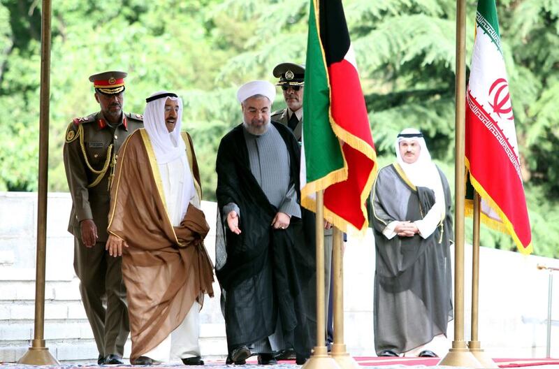Iranian president Hassan Rouhani and Sheikh Sabah al-Ahmad al-Sabah, the emir of Kuwait, centre left, review the honor guard during a welcoming ceremony for the emir upon his arrival in Tehran on Sunday. Kuwait's Emir started a landmark visit to Tehran focused on mending fences between Shiite Iran and the Sunni-ruled monarchies in the Gulf. Atta Kenare / AFP

