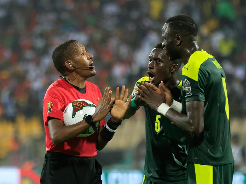 Senegal's Idrissa Gana Gueye argue with referee Bamlak Tessema Weyesa. Reuters