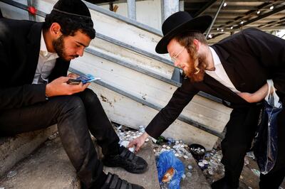 An ultra-Orthodox Jewish man prepares to light candles at the site where dozens were crushed to death in a stampede at a religious festival, as the country observes a day of mourning, at Mount Meron, Israel May 2, 2021. REUTERS/Amir Cohen