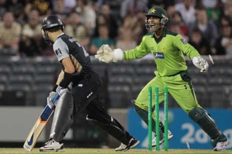 Pakistan wicketkeeper Umar Akmal (R) celebrates after New Zealand batsman Peter McGlashan is bowled out for 7 runs during their third Twenty20 international cricket match at the AMI Stadium in Christchurch on December 30, 2010. Pakistan beat New Zealand by 103 runs.  AFP PHOTO / BRENDON O'HAGAN

