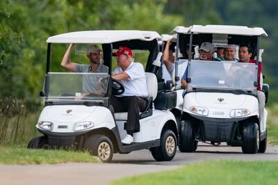 Former President Donald Trump drives a cart at Trump National Golf Club with his son Eric Trump on his left, on September 12, in Sterling, Vermont, US. AP