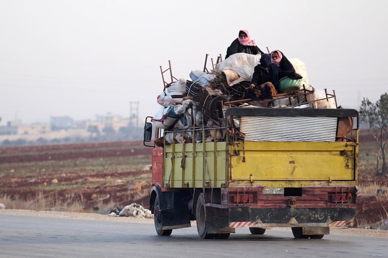 A displaced family from a village in southern Idlib head on the Damascus-Aleppo motorway towards the northern part of the rebel-held province on December 29, 2017. 
Clashes pitting mainly jihadist and rebel fighters against regime forces backed by Russian warplanes killed at 66 people on the edge of Syria's northwestern Idlib province, a monitor said. / AFP PHOTO / OMAR HAJ KADOUR