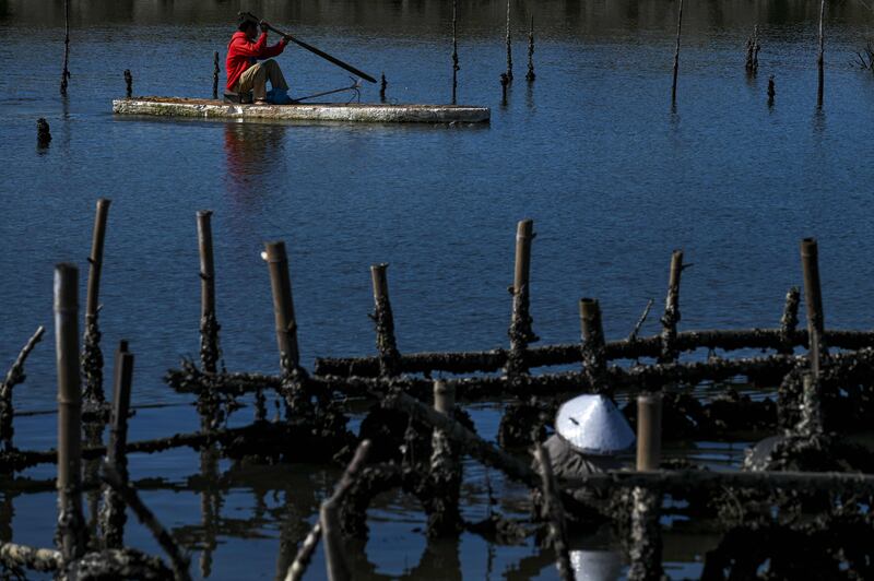 A man paddles on a canoe while fishisng at an oyster farm in Banda Aceh, Indonesia. AFP