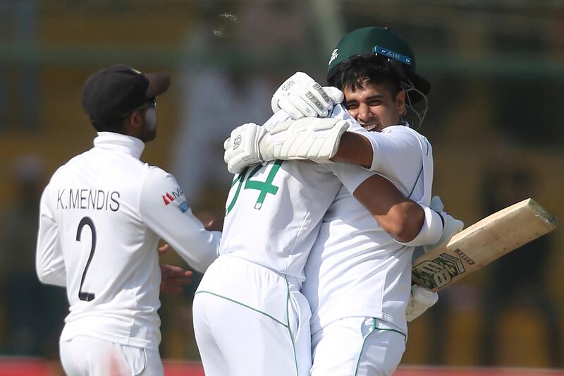 Pakistan's Abid Ali, right, celebrates his century with teammate Shan Masood in Karachi on Saturday. AP