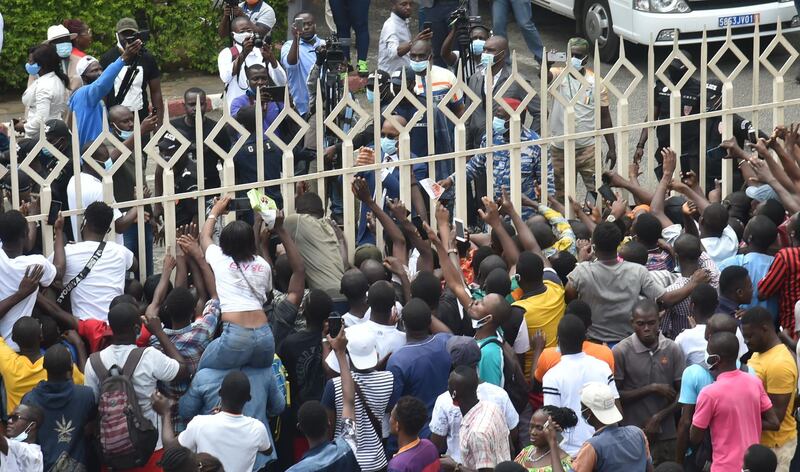 Didier Drogba greets supporters from behind a fence. AFP