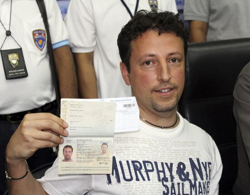 Italian Luigi Maraldi, left, whose stolen passport was used by a passenger boarding a missing Malaysian airliner, shows his passport as he reports himself to Thai police at Phuket police station. Krissada Muanhawang / AP Photo March 10