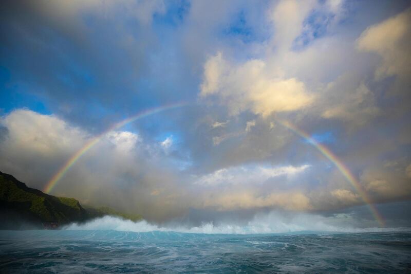 A rainbow pierces through the clouds behind the famous break of Teahupoo in Tahiti, French Polynesia. AFP