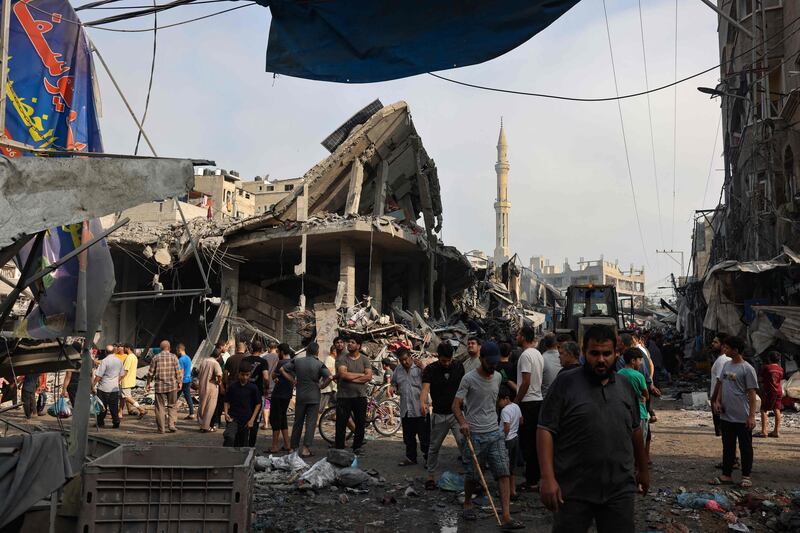 People gather amid the destruction following Israeli strikes on Al Shatee camp in Gaza city. AFP