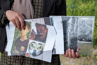 Bahar Elias, 40, a displaced Yazidi, holds pictures of her family members kidnapped by ISIS. AFP