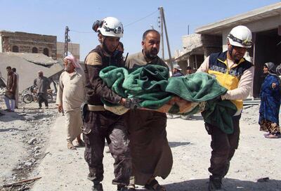 This photo provided by the Syrian Civil Defense group known as the White Helmets, shows members of the Syrian Civil Defense workers carrying a victim after a deadly airstrike hit a market killing several people in the village of Ras el-Ain, in the northwestern province of Idlib, Syria, Tuesday, May 7, 2019. Opposition activists say government forces have intensified their bombardment of rebel-held towns and villages in northwestern Syria. (Syrian Civil Defense White Helmets via AP)