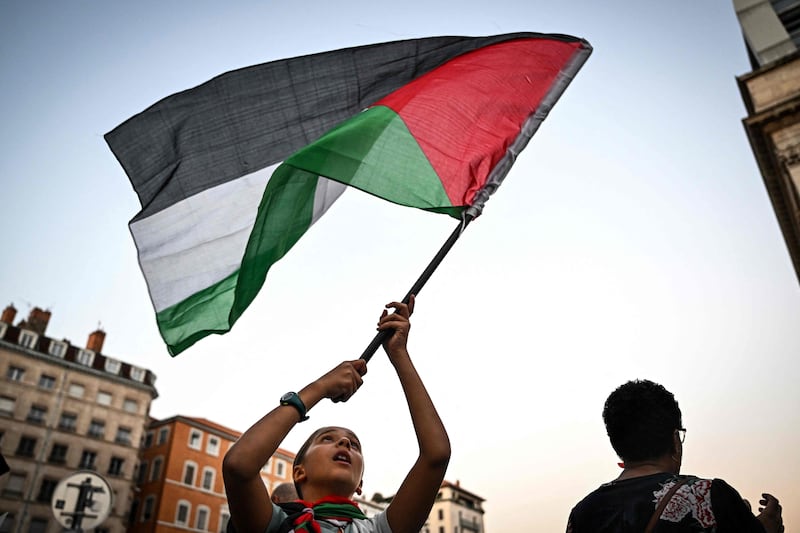 A protester waves a Palestinian flag during a rally in Lyon, France. AFP