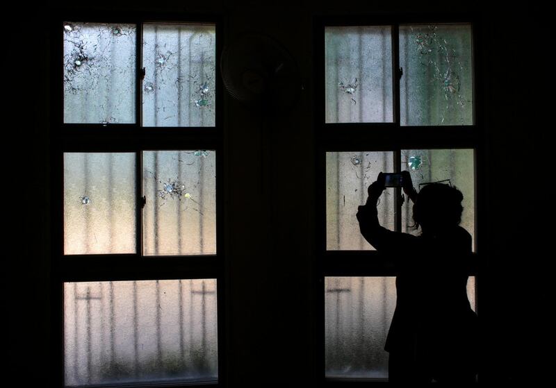 A woman uses her mobile phone to take pictures of bullet holes in windows damaged during the attack on the Divine Mercy Church last year when a group of demonstrators protested against Nicaraguan President Daniel Ortega's government in Managua. Reuters