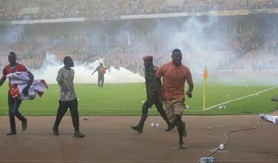 Police fire tear gas after a pitch invasion at the end of Nigeria's World Cup qualifier against Ghana in Abuja on Tuesday. AP