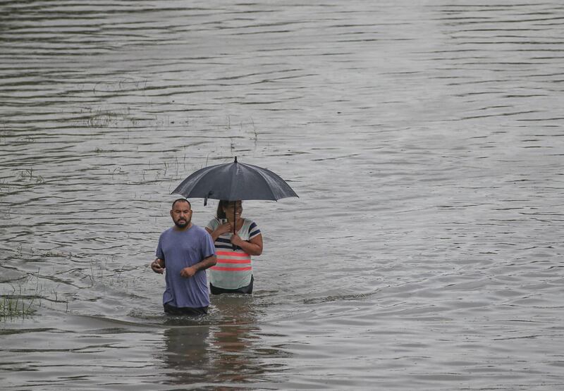 People walk the flooded waters after heavy rain and flooding from the remnants of Tropical Depression Imelda dumped more than two feet of water across some areas. Getty
