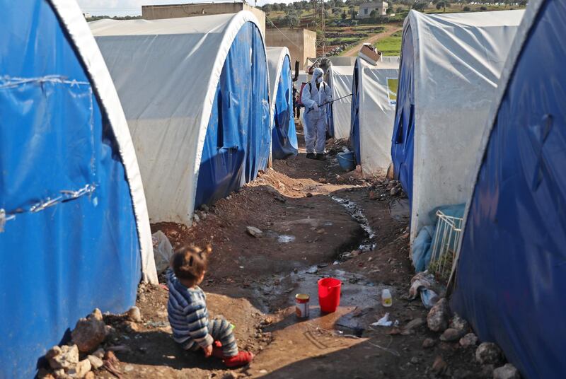 A member of the Syrian Violet NGO disinfects tents at a camp for displaced people in Kafr Jalis village, north of Idlib city.  AFP