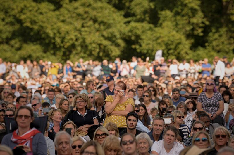 A woman wipes away tears as she joins people sitting in Hyde Park. AP