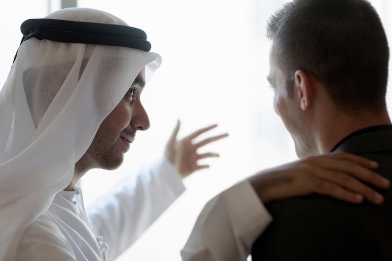 Two Arab businessmen. One in traditional clothing other in western clothing. Getty Images