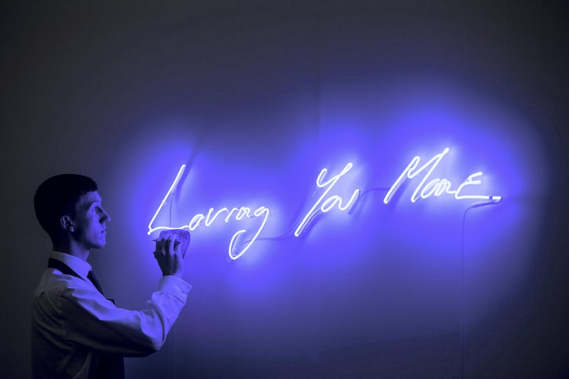 LONDON, ENGLAND - OCTOBER 12:  A Sotheby's art handler poses for photographs next to Loving You More by Tracey Emin, estimated at £25,000-£35,000, during an Art for Grenfell press call at Sotheby's Art for Grenfell preview on October 12, 2017 in London, United Kingdom. The 'Art for Grenfell' auction will take place on October 16 2017 and includes work by contemporary artists.  (Photo by Chris J Ratcliffe/Getty Images for Sotheby's)