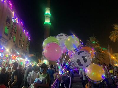 This May 2, 2021 photo shows a balloon seller at the historical El Moaz Street in Cairo‚Äôs Islamic quarter. Hamza Hendawi/ The National.