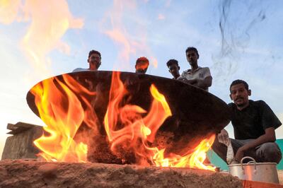 Refugees from Sudan's civil war sit around a fire in Wadi Halfa near Egypt. AFP