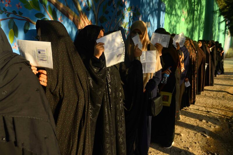 TOPSHOT - Afghan women voters queue prior to casting their ballot at a polling station herat on September 28, 2019. Afghans headed to the polls amid tight security as voting got under way in the presidential election, following a bloody campaign that has been marred by repeated attacks across Afghanistan. / AFP / HOSHANG HASHIMI
