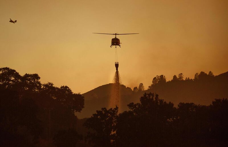 A helicopter drops water while helping to fight the Mendocino Complex fire in Lakeport, California.  AFP PHOTO / JOSH EDELSON