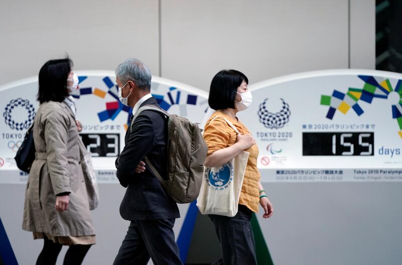 Pedestrians walk past a Tokyo Olympics countdown clock in Tokyo. EPA