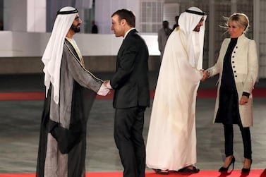 Ruler of Dubai Sheikh Mohammed bin Rashid al-Maktoum (L) shakes hands with French President Emmanuel Macron (C-L) as Abu Dhabi Crown Prince Mohammed bin Zayed Al-Nahyan (2nd R) greets the president's wife, Brigitte Macron, at the entrance of the Louvre Abu Dhabi Museum on November 8, 2017 during its inauguration on Saadiyat island in the Emirati capital. - More than a decade in the making, the Louvre Abu Dhabi is opening its doors bringing the famed name to the Arab world for the first time. (Photo by KARIM SAHIB / AFP)