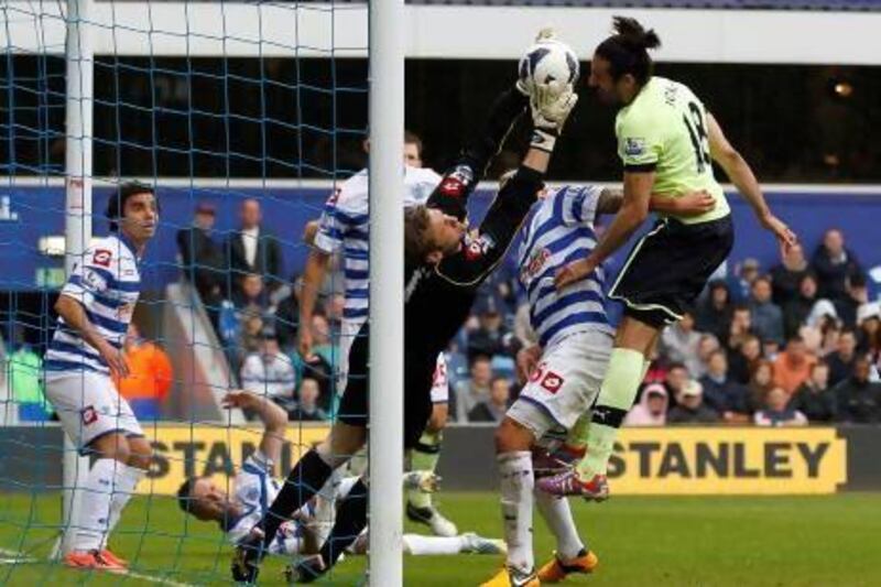 Robert Green, left, the QPR goalkeeper catches the ball under a challenge from Jonas Gutierrez. Ian Kington / AFP