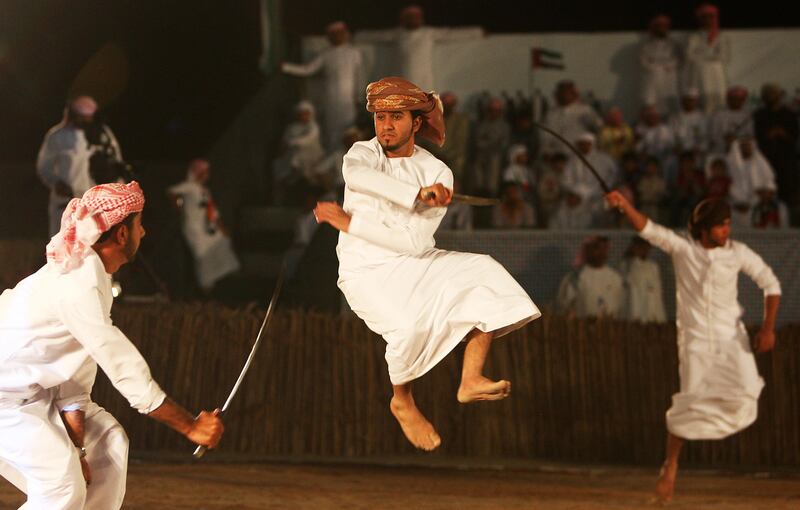 
FUJAIRAH , UNITED ARAB EMIRATES Ð Dec 2 : Mohammed Ahmed ( 19 years old in the center jumping ) from Al Shehhi tribes taking part in the sword championship with other participants at the Fujairah Fort in Fujairah. Today UAE is celebrating itÕs 40th National Day. ( Pawan Singh / The National ) For News. Story by Rym. This is the final photo to go with Rym Story. 
