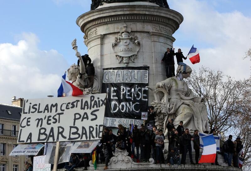 A placard reading ‘Islam is peace, not barbarism’ is held up against another that says ‘Charlie, I think therefore I am’ during a peace rally in Paris following the killings at Charlie Hebo magazine in January 2015. AFP Photo