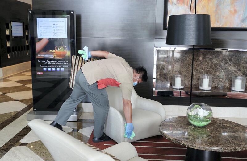 DUBAI, UNITED ARAB EMIRATES , July 8 – 2020 :- Cleaning staff disinfecting the sitting area at the Towers Rotana hotel on Sheikh Zayed road in Dubai. After each use, cleaning staff disinfect the sitting area at the reception as a  preventive measure against the spread of coronavirus. (Pawan Singh / The National) For News/Standalone/Online/Stock