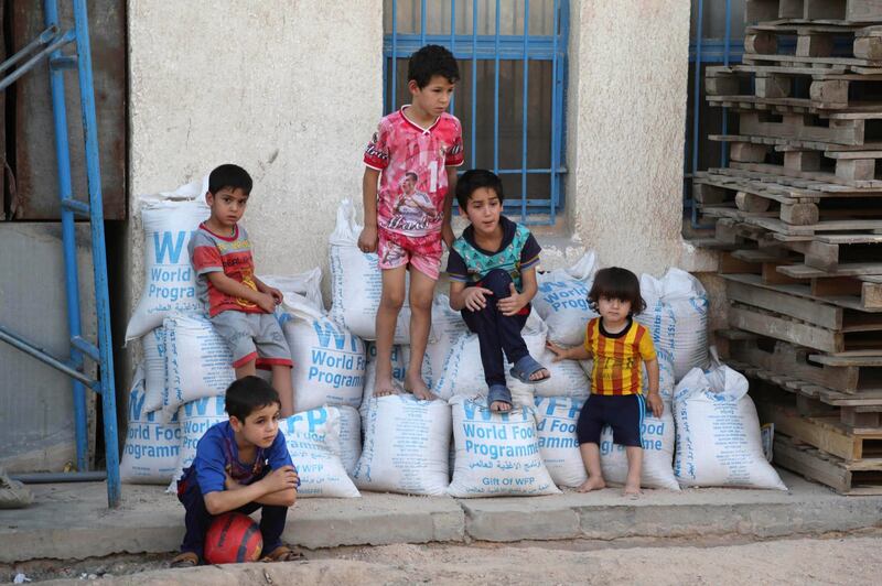 FILE - In this Friday, June 19, 2015 file photo, children sit on bags of rice from the World Food Program (WFP) at a school that serves as a shelter for internally displaced people in Baghdad's eastern district of Jamila, Iraq. The World Food Program on Friday, Oct. 9, 2020 won the 2020 Nobel Peace Prize for its efforts to combat hunger and food insecurity around the globe. (AP Photo/Karim Kadim, File)