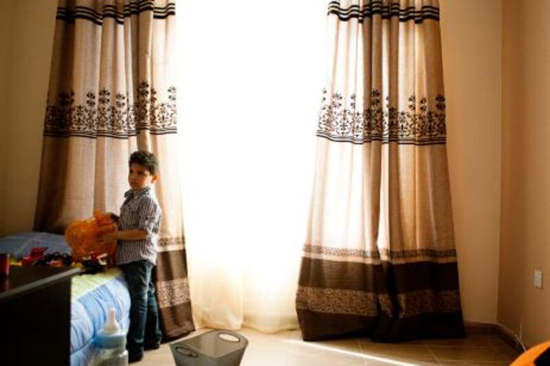 February 16, 2011 - Abu Dhabi, UAE - Yousef Hassan, 5, plays with toys in his room on Wednesday February 16, 2011.  Residents of villas in Abu Dhabi Gate City may be evicted from their homes because the municipality has deemed them illegal. (Photo by Andrew Henderson / The National)