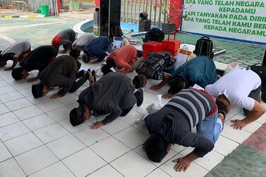 Inmates praying after they were released due to concerns of coronavirus in Majene, Indonesia. AFP