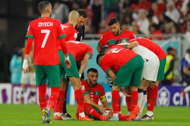Morocco's defender #06 Romain Ghanem Saiss (C) reacts on the ground due to an injury  during the Qatar 2022 World Cup quarter-final football match between Morocco and Portugal at the Al-Thumama Stadium in Doha on December 10, 2022.  (Photo by Odd ANDERSEN  /  AFP)