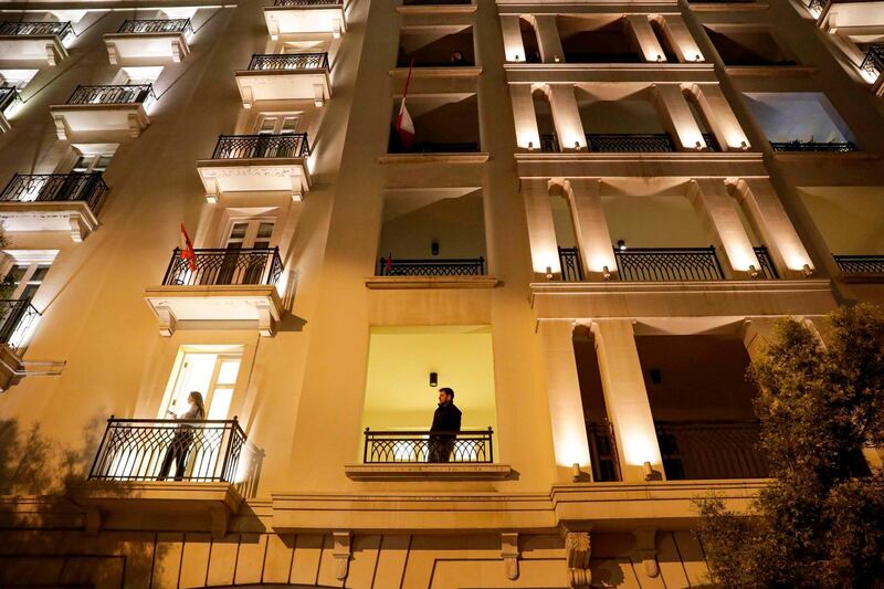 People look out from balconies to view a demonstration near the home of former prime minister Saad Hariri in central Beirut on December 16, 2019.  AFP