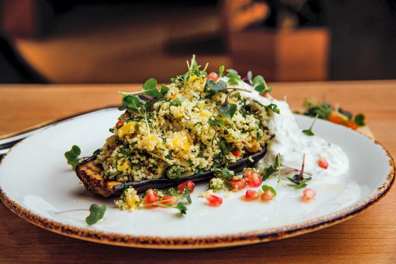 Roasted eggplant with couscous at Refresh Delux Cafe: the vegetarian and plant-based vegan dishes on this cafe's menu link back to the Mediterranean diet, where meat was only consumed by the wealthy or for a festive occasion. The eggplant is sourced from Greece, in line with the owner’s Greek heritage, and it is baked and filled with a herby couscous and served with tzatziki dip