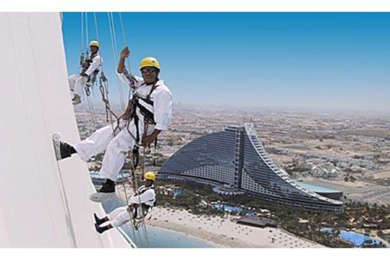 Armed with ropes and cleaning equipment, climbers clean the exterior of the Burj Al Arab.