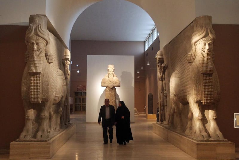 Visitors to the official opening of the Iraq Museum in Baghdad walk between two lamassu statues, a deity depicted as a winged bull with a human head. Ahmad Al Rubaye / AFP