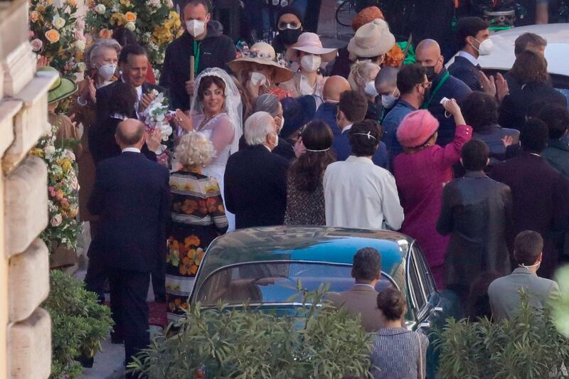 Lady Gaga, wearing a wedding dress in background left, plays Maurizio Gucci's former wife Patrizia Reggiani. AP photo